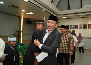 Direktur Utama PTPN IV PalmCo, Jatmiko K. Santosa saat menggendong salah seorang anak yatim piatu
